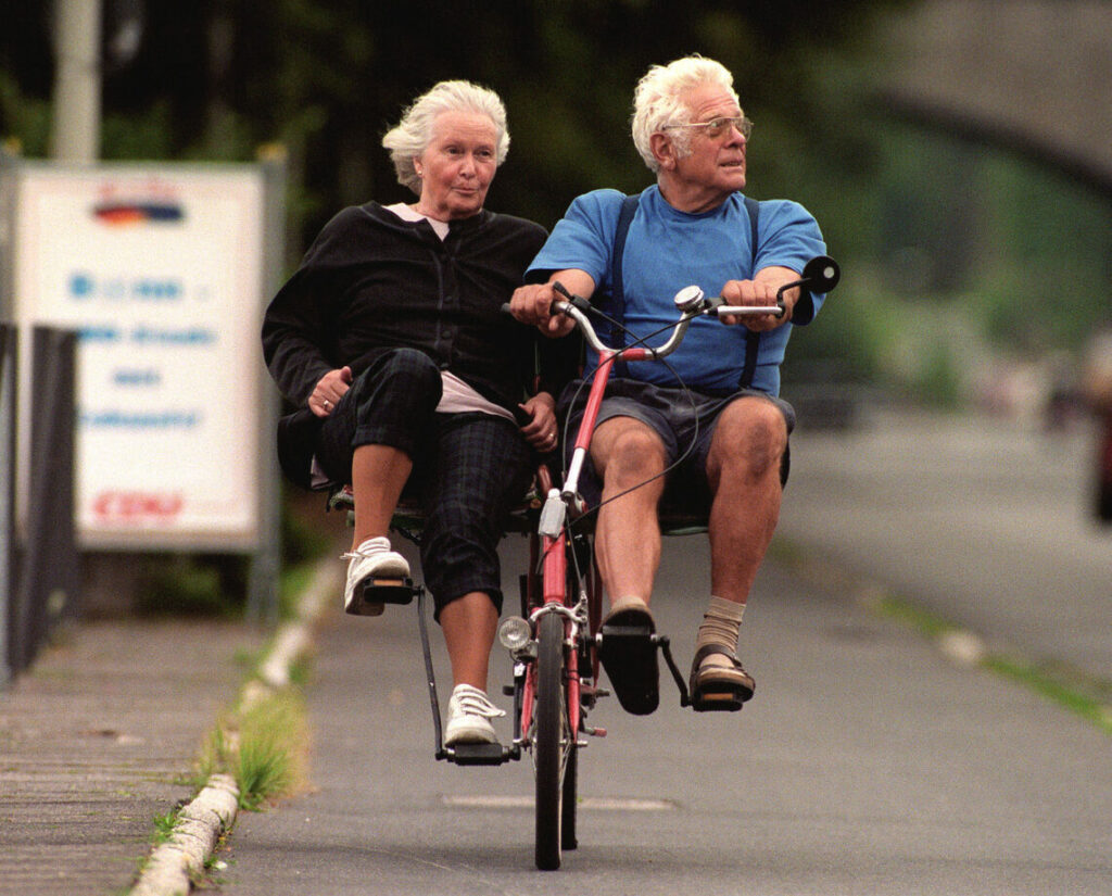 Seniorenehepaar auf einem selbstgebastelten Tandem